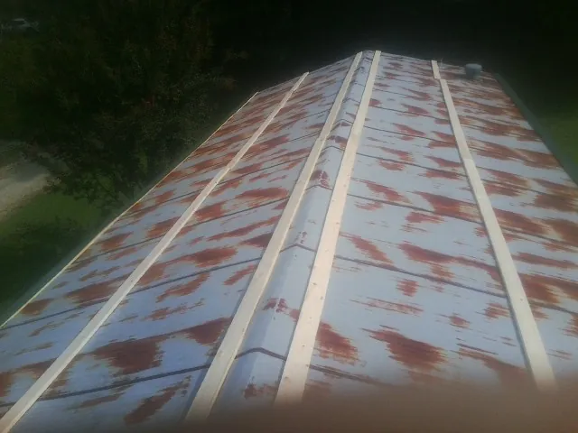 Rusted metal roof panels with new wood purlins before replacement — Storm Damage Roof Repair in Harpersville by Roofing Brothers