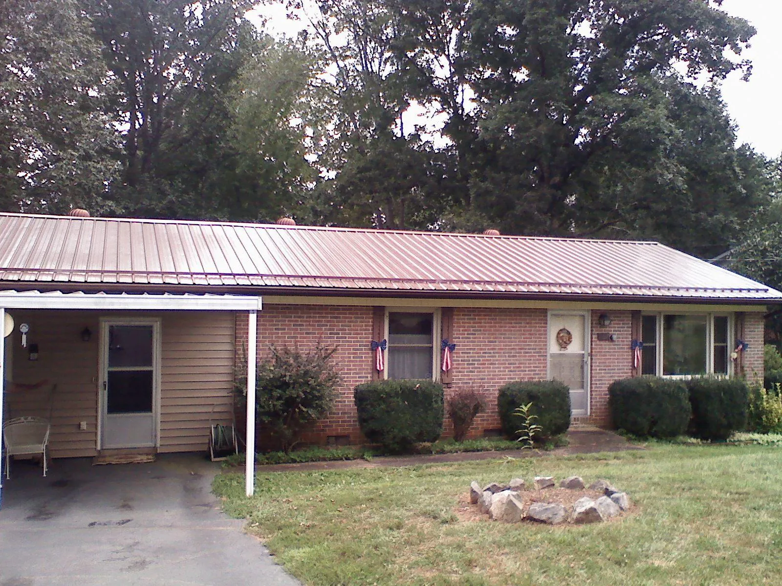 Bronze metal roof and carport on a brick ranch home — Roof Repair work by our crew in Harpersville