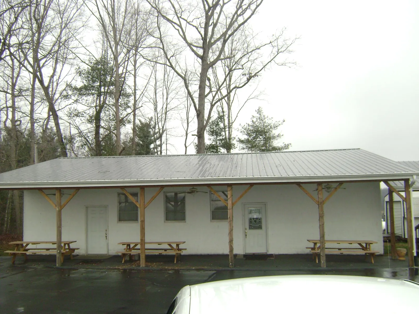 Gray metal roof over a block building with a timber post porch in Harpersville